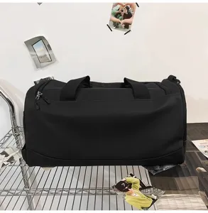 Vue détaillée du grand sac de voyage noir avec poignées résistantes et fermeture éclair.