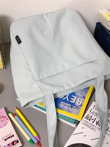Detail view of mint green casual tote bag featuring front pocket and dual shoulder straps