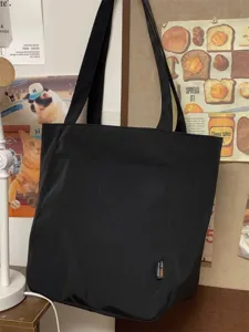 Black canvas tote bag detail, casual minimalist shoulder bag for women daily use.