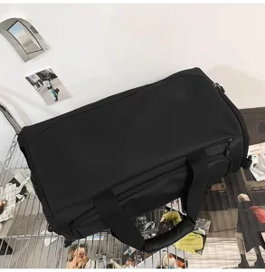 Vue détaillée du sac de voyage noir montrant la texture, la grande capacité et la séparation.