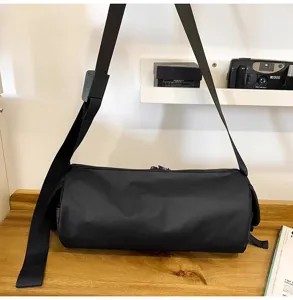 Schwarze wasserdichte zylindrische Sporttasche mit verstellbarem Schultergurt für Outdoor.