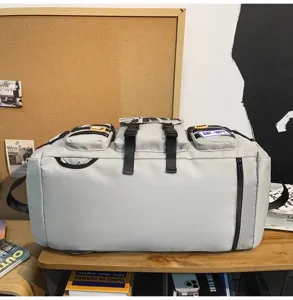 Borsa da viaggio multifunzionale grigio chiaro, con dettagli di tasche e cinghie.