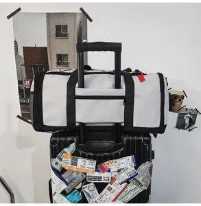 Travel duffel bag detail showing trolley sleeve and durable black straps for easy luggage transport.