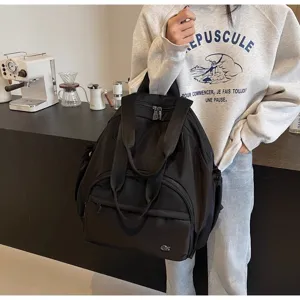 Grande zaino nero in nylon per viaggi e uso quotidiano, borsa fasciatoio multifunzionale.