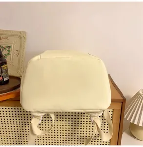 Detailansicht des hellgelben Canvas-Rucksackbodens und der Schultergurte in gemütlichem Zimmer.