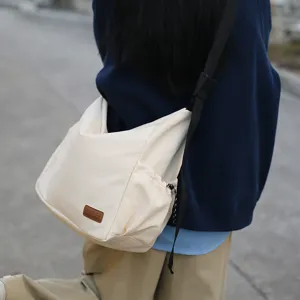 Casual large capacity canvas crossbody bag for women and men, lightweight daily messenger bag.