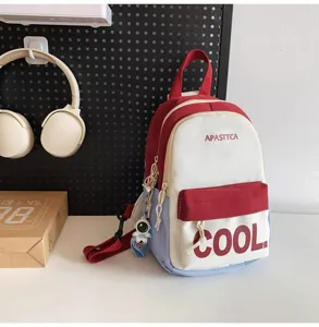 Detailed view of the stylish color-block mini backpack with astronaut pendant and front pocket.