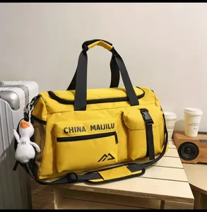 Detailaufnahme der gelben Reisetasche mit Fronttasche, Seitentasche und stabilem Schultergurt.