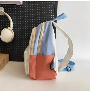 Small color-block backpack side detail, multi-color casual school bag with zipper pockets.