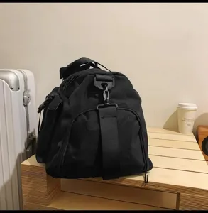 Nahaufnahme Detail der schwarzen Reisetasche mit strapazierfähigem Gurt und Seitentasche.