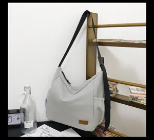 Casual gray canvas shoulder bag with spacious interior and adjustable black strap detail.