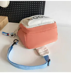 Detailed view of the pink and white colorblock crossbody chest bag with adjustable strap.