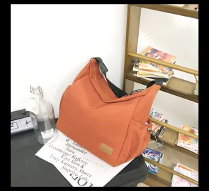 Large capacity canvas messenger bag for casual travel and daily use, stylish orange shoulder bag.