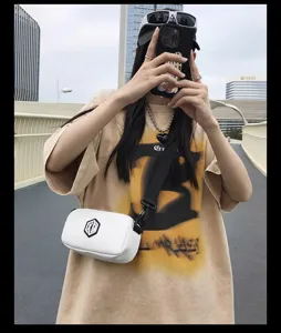 Minimalist white crossbody bag with black strap, trendy streetwear fashion shoulder bag.
