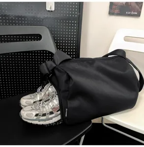 Detailansicht der schwarzen Reisetasche mit separatem Schuhfach und integriertem Stofflogo.
