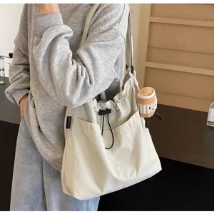 Vista detallada del bolso tote grande de lona casual para mujer con cordón y correa de hombro.