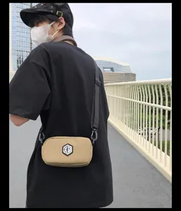 Detail shot of a casual men's waterproof crossbody phone bag in beige with strap.