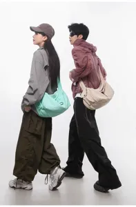 Casual crossbody bag detail showing large capacity, wide strap, and durable fabric material.