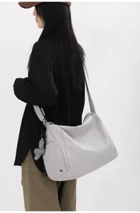 Detailansicht einer großen grauen Reisetasche mit praktischer Seitentasche und stabilem Schultergurt.