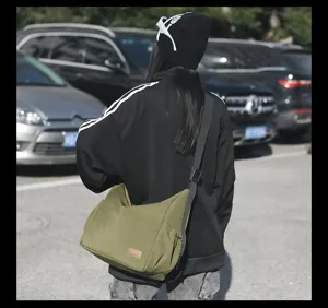 Casual large capacity canvas messenger bag for men and women, versatile travel shoulder bag.