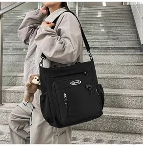 Large capacity canvas shoulder bag casual crossbody tote bag with cute monkey pendant.