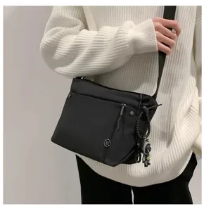 Stylish black nylon crossbody bag for women, lightweight casual shoulder bag with pendant.