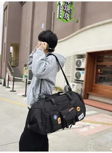 Dettaglio borsa da viaggio nera capiente, stile streetwear all'aperto con tasche.