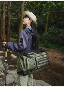 Detail view of large capacity outdoor travel duffel bag, with multiple pockets and durable green fabric.