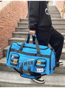 Primo piano della grande borsa da viaggio blu con tasche multiple e cinghie resistenti.