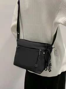 Black nylon crossbody bag for women, lightweight casual shoulder bag with zipper and pendant.