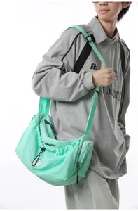 Close-up detail of the mint green crossbody bag showing its adjustable strap and drawstring.