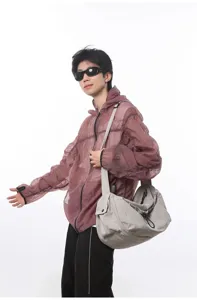 Detail shot of the large capacity casual crossbody travel bag worn by the male model clearly.