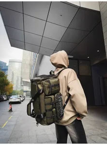 Outdoor street detail view of a large tactical travel backpack with multiple multi-functional pockets.