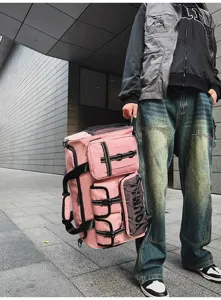 Detail view of large pink travel gym bag with multiple exterior pockets and straps for sports.