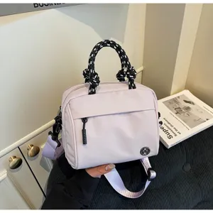 Vista dettagliata della borsa a tracolla casual con scomparti multipli e manici intrecciati.