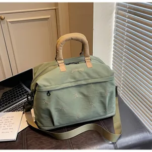 Large capacity green travel duffel bag with cute bow embroidery and sturdy handles for trips.