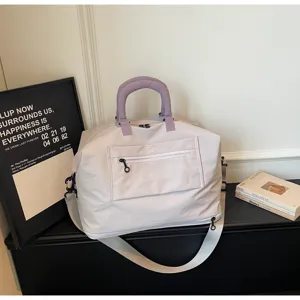 Expandable large capacity travel duffel bag with purple handles, shoulder strap and zipper pocket.