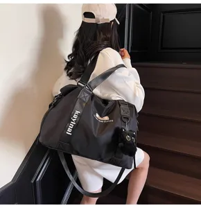 Schwarze Reisetasche mit Katzenanhänger, sportive Sport- und Yogatasche für Damen im Alltag.