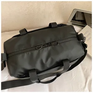 Close-up detail of black waterproof gym duffel bag with dual zippers and adjustable strap.