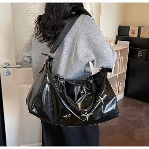 Large capacity black glossy travel shoulder bag with metal star rivets and dual handles.