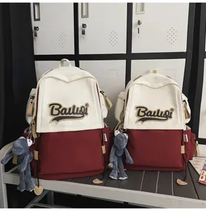 Large capacity colorblock canvas school backpack with cute plush doll pendant for daily use.