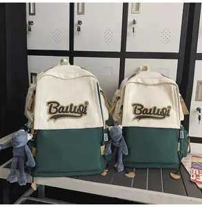 Detailed close-up view of the canvas contrast color backpack with cute doll pendant.