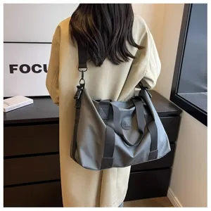 Gran bolsa de viaje gris en tejido impermeable con correas fuertes para fin de semana y deporte.