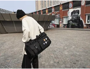 Sac de sport tactique noir avec de multiples poches de rangement et sangle d'épaule.