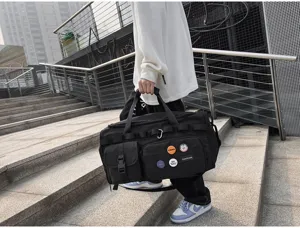 Vue détaillée du grand sac de sport noir avec sangles tactiques et badges décoratifs.