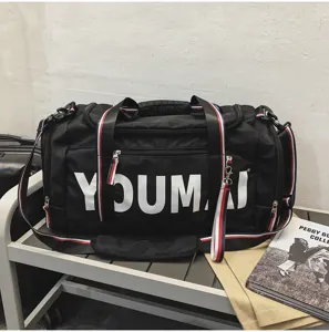 Detailed view of large capacity black travel duffel bag with striped handles and front logo.