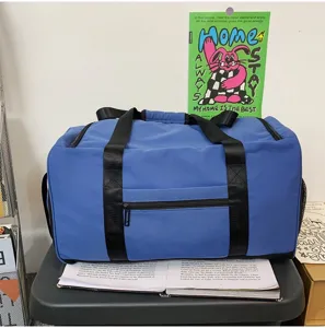 Blue travel duffel bag detail, large capacity sports gym bag with sturdy handles and front pocket.