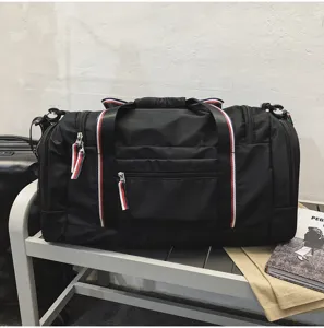 Detail view of large capacity black travel gym duffel bag with red white blue stripe webbing.