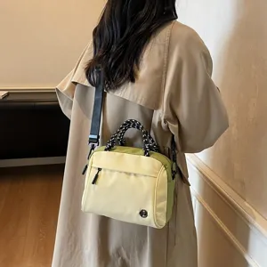 Dettaglio di una elegante borsa a tracolla con manici intrecciati per le donne.