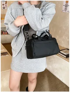 Compact black waterproof gym bag and crossbody shoulder bag, lightweight travel accessory.